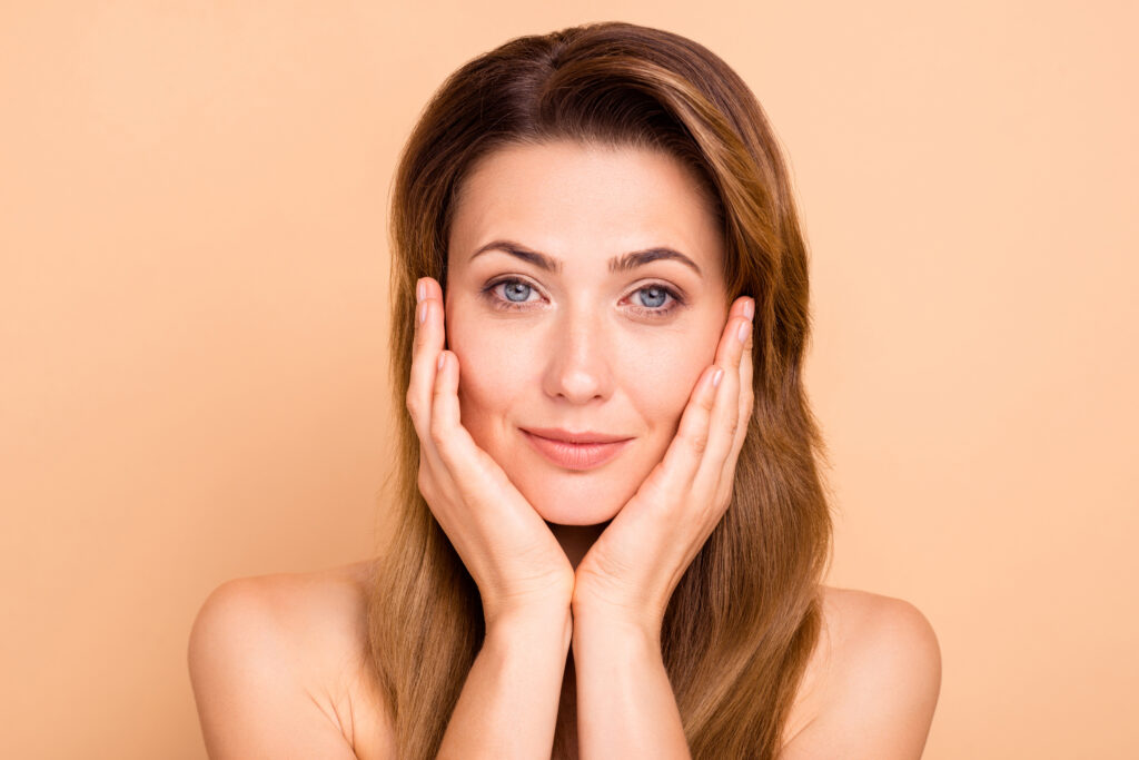 A woman touching her cheeks after cold laser therapy in Alpharetta