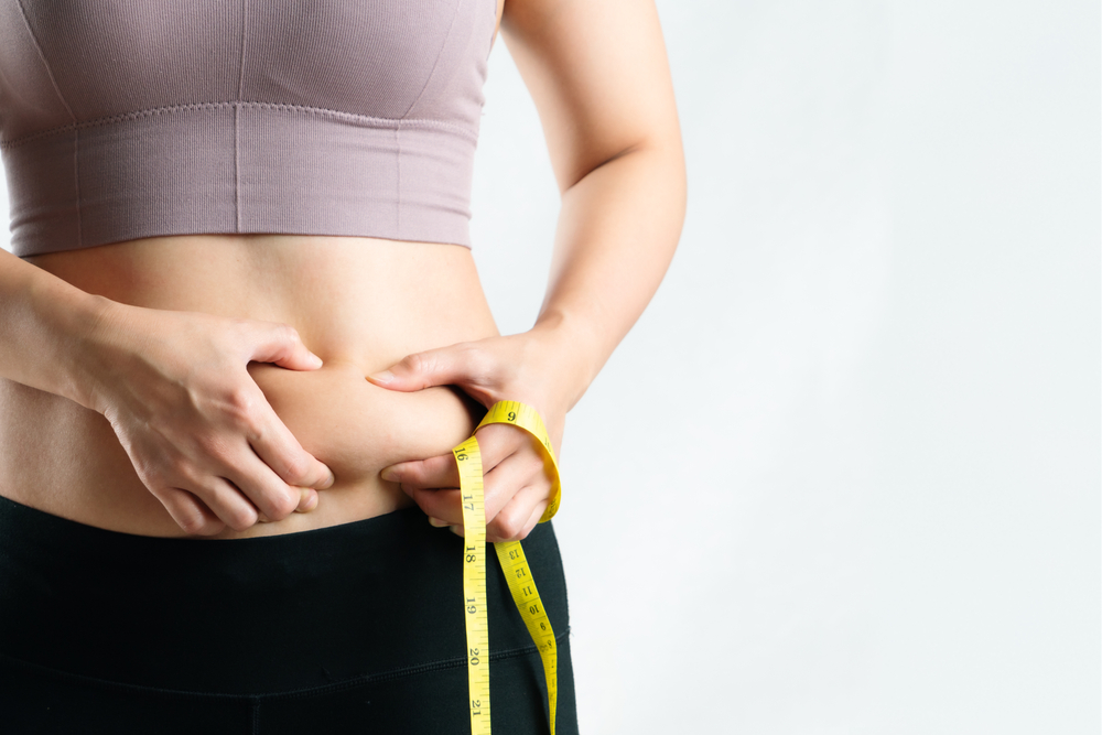 Woman pinching belly fat before starting GLP-1 treatment in Alpharetta